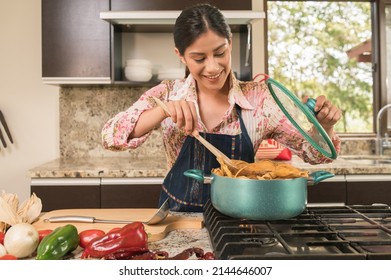 Beautiful woman cooking corn tamales.