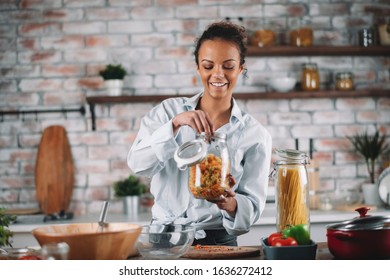 Beautiful woman cooking and having fun at the kitchen. Girl cooking healthy meal in kitchen. 