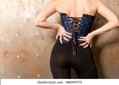 Beautiful Woman In A Corset At The Iron Wall