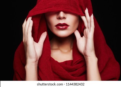 beautiful woman covers her face with a colored hood. red lips make-up girl. part of female face