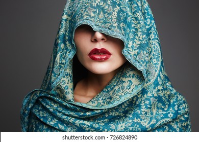 beautiful woman covers her face with a colored cloth.red lips make-up girl. part of female face