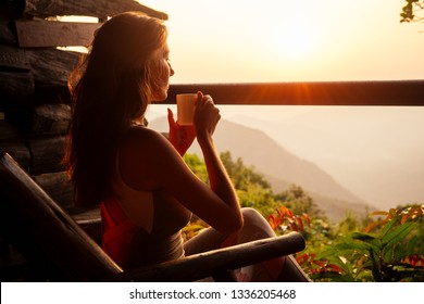 Beautiful Woman With Cup Of Coffee Tea Enjoying The View From The Balcony On Tea Plantation Jungle At India Kerala Goa Wildernest Nature Spa Resort