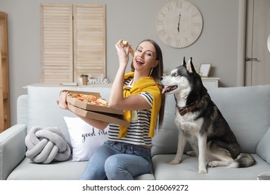 Beautiful woman with cute dog eating tasty pizza at home