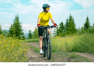 Beautiful woman cyclist rides a bicycle in nature. Healthy lifestyle and sports. Leisure and hobbies