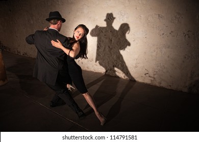 Beautiful woman with dance partner performing a tango routine