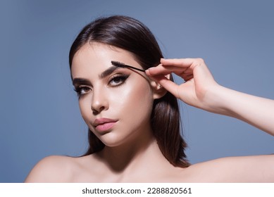 Beautiful woman with dark eyebrows hold eyebrow brush. Eyebrows lamination. Brow beauty procedures. Combs eyebrows with a brus, eyebrow eye line.