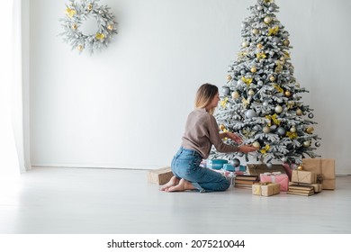 beautiful woman decorates a white Christmas tree new year gifts decor - Shutterstock ID 2075210044