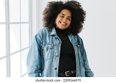 Beautiful Woman In Denim Jacket Smiling. Happy Female Model With Curly Hair Looking At Camera And Smiling.