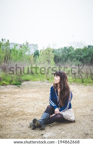 Similar – Junge Frau sitzt auf einer Bank in einem Park in ruhiger Pose.