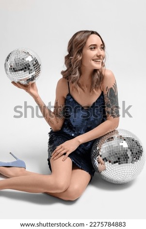 Beautiful woman with disco balls on white background