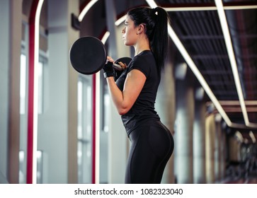 Beautiful Woman Doing Biceps Curl With Barbell In A Gym