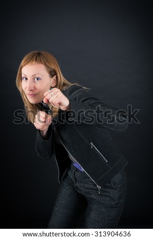 Similar – Image, Stock Photo Close up front portrait of one young middle age athletic woman in sportswear in gym over dark background, standing in boxing stance with hands and fists, looking at camera