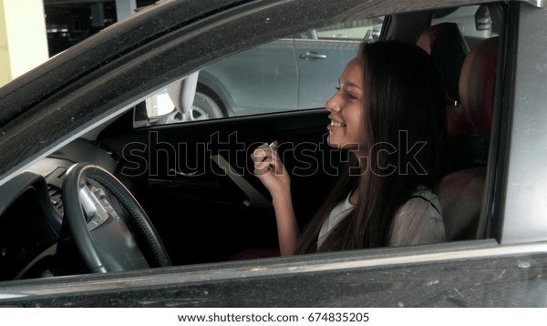 beautiful woman doing makeup in the business class\
car with red chairs
