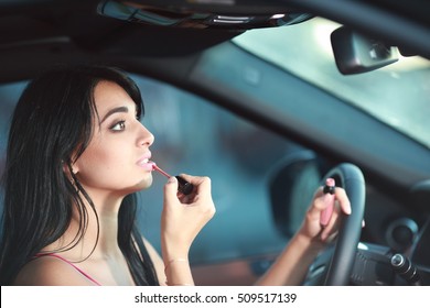 beautiful woman doing makeup in the car