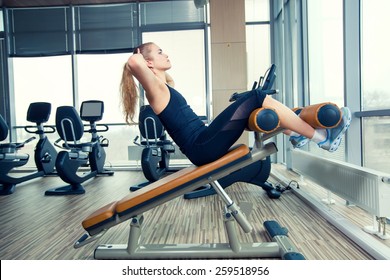 Beautiful woman doing press fitness exercise at sport gym.