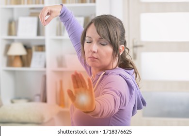 Beautiful Woman Doing Qi Gong Tai Chi Exercise At Home