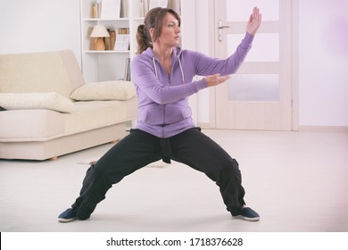 Beautiful Woman Doing Qi Gong Tai Chi Exercise At Home