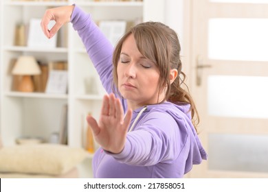 Beautiful Woman Doing Qi Gong Tai Chi Exercise At Home