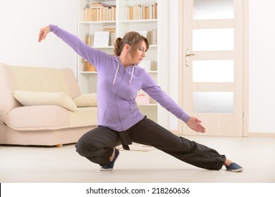 Beautiful Woman Doing Qi Gong Tai Chi Exercise At Home