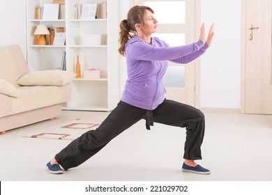 Beautiful Woman Doing Qi Gong Tai Chi Exercise At Home