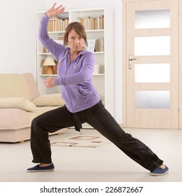 Beautiful Woman Doing Qi Gong Tai Chi Exercise At Home