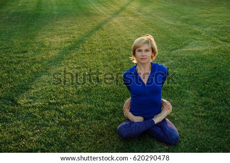 beautiful woman doing yoga exercises in park
