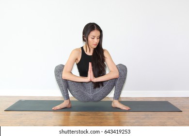 Beautiful Woman Doing A Yoga Pose Called Squat Pose, Or Malasana Pose.