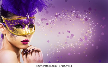 beautiful woman with dramatic mekaup and pruple lipstick wearing puprle mask. Light background. Golden. 
