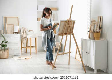 Beautiful woman drawing picture on canvas in studio - Powered by Shutterstock