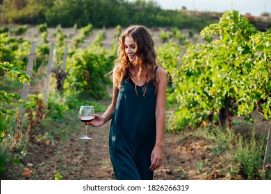 beautiful woman in dress with a glass of wine at a picnic in the vineyard