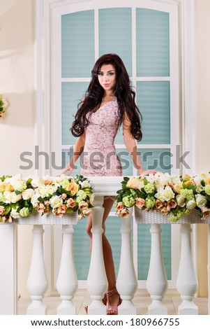 A beautiful woman in a dress. The picture on the balcony