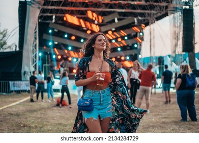 Beautiful woman drinking beer and having fun on a festival with her friends