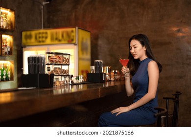 Beautiful Woman Is Drinking Cocktail And Having Enjoy To Relaxing While Sitting Alone To Listening Music On Counter Bar In Restaurant Or Hotel Bar