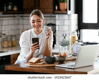 Beautiful woman drinking coffee and using the phone in the kitchen. Young woman talking to the phone..	 - Powered by Shutterstock