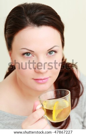 Beautiful woman drinking a cup of tea with lemon