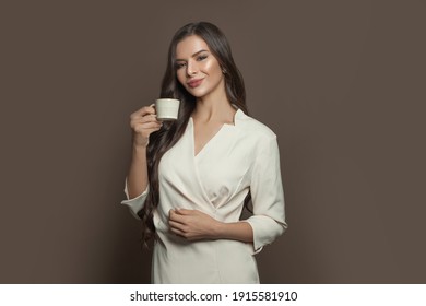 Beautiful woman drinking espresso coffee on brown background