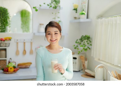 Beautiful Woman Drinking Milk In Kitchen At Home