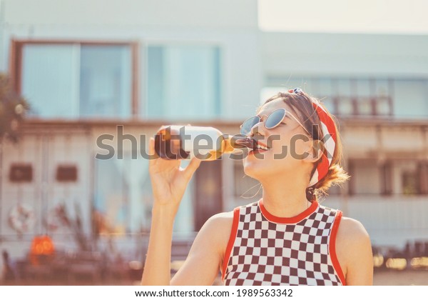 Beautiful woman\
drinking soda on the\
beach.