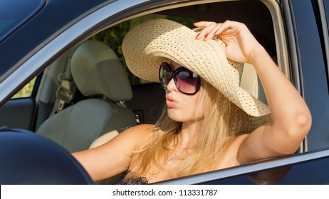 Beautiful Woman Driver In Straw Hat Sitting In The Hot Sun With The Car Window Rolled Down