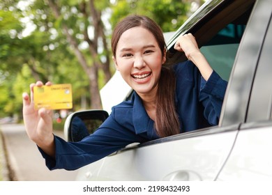 Beautiful Woman Driving A Car Parked On The Side Of The Road Smiling Happy Holding A Credit Card To Pay For Car Repairs. Concept Of Car Insurance. Card Instead Of Cash. Pay For Tires, Maintenance