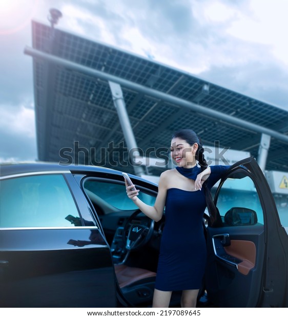 Beautiful woman driving a luxury car and using\
electric cars at sola EV\
charger.