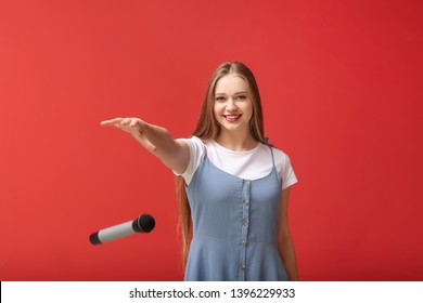 Beautiful woman dropping microphone on color background