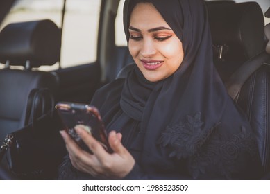 Beautiful woman in Dubai wearing abaya traditional female dress driving the car. Concept about uae and women rights