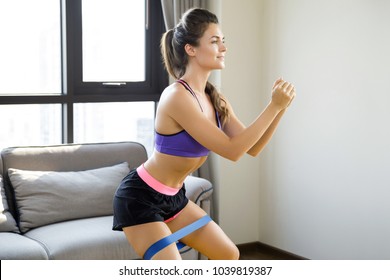 Beautiful Woman During Her Home Workout With A Rubber Resistance Band