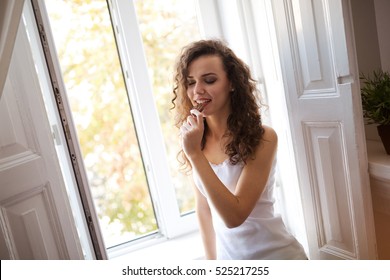 Beautiful woman eating cookie and smiling