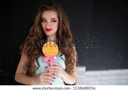 Beautiful woman eats a big candy sweet lollipop