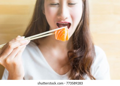 Beautiful Woman Enjoy Eating At A Sushi Restaurant, Selective Focus Of Sashimi Don.