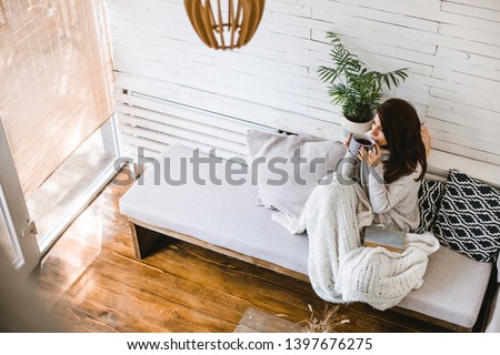 Beautiful woman enjoying cup of tea in her cosy house