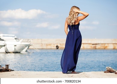 Beautiful woman enjoying with a fresh sea breeze on marine vacation in the yacht club