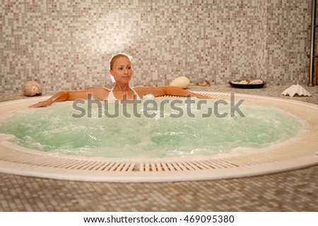 Beautiful woman enjoying in Jacuzzi at the spa center.